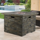 Stone-patterned outdoor fire pit table on a patio with pool and chairs in the background