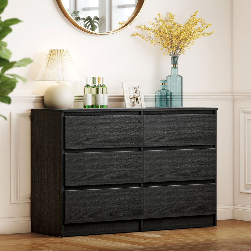 Black dresser with 6 Roller Drawers decorative items in a room with a mirror and plant.
