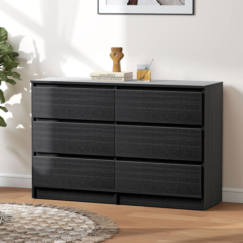 Black dresser with 6 drawers and decorative items on top in a room setting