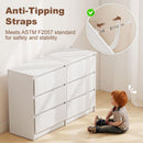 White dresser with anti-tipping straps and child sitting on the floor, emphasizing safety.