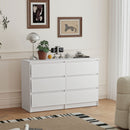 White 6-drawer dresser in a room with decor elements like a lamp, plant, and clock.