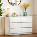 White dresser with decorative items in a room setting