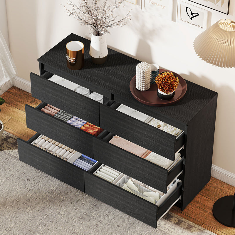 Black dresser with open drawers in a bedroom setting