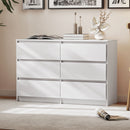 White dresser with six drawers in a room setting with decorative accessories on top
