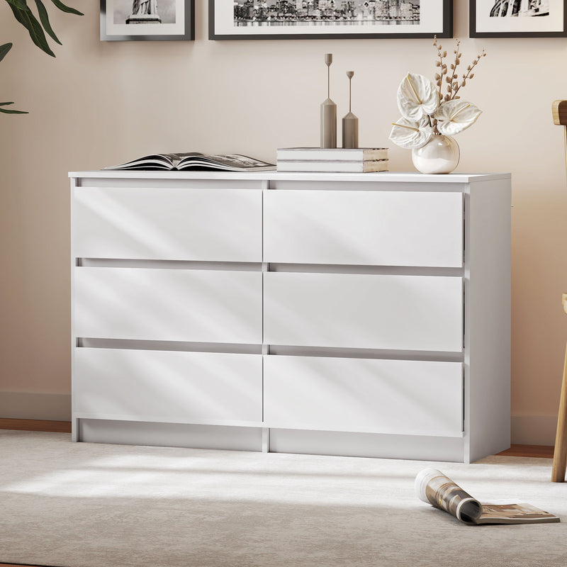White dresser with six drawers in a room setting with decorative accessories on top