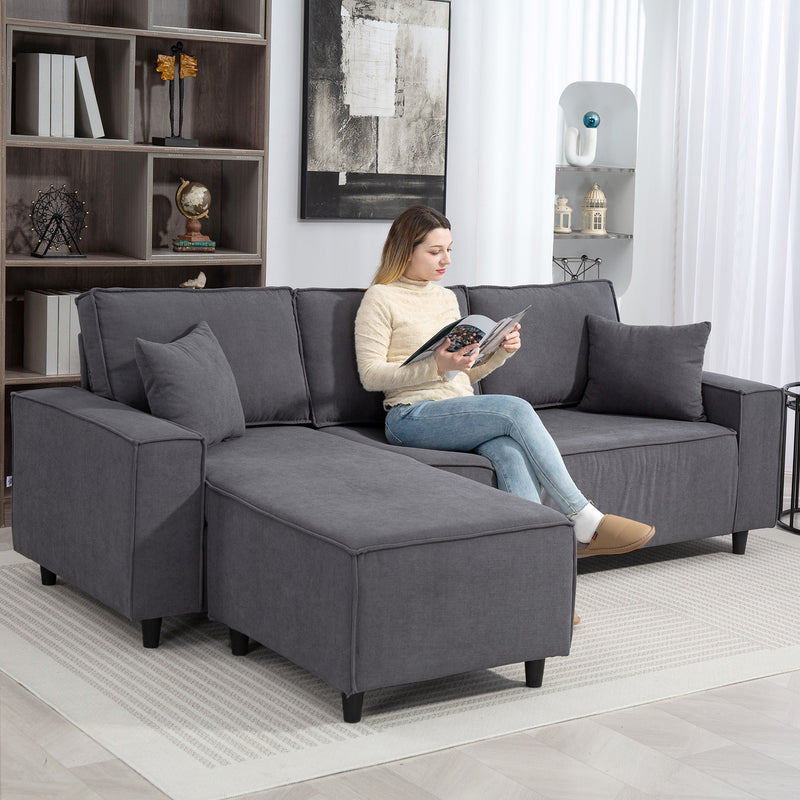 Woman sitting on a gray sectional sofa reading a magazine in a modern living room.